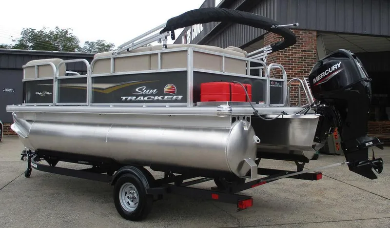 Slide: The Image of 2025 Sun Tracker PARTY BARGE® 16 DLX pontoon boat on trailer, featuring Mercury outboard motor. - 5