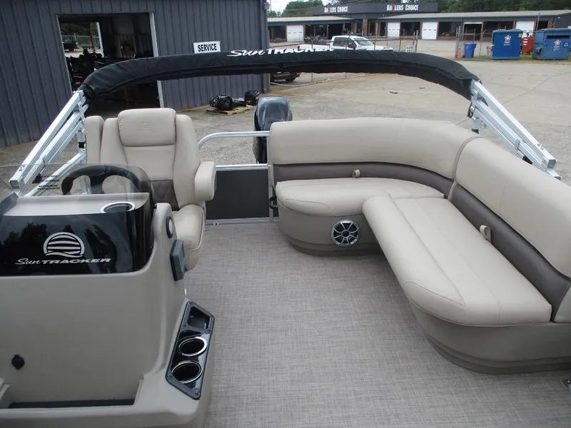 Slide: The Image of 2025 Sun Tracker PARTY BARGE® 16 DLX interior with beige seating and steering console. - 7