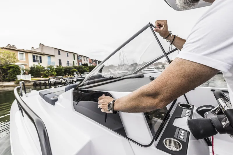 Slide: The Image of 2025 Axopar 25 Cross Top cabin interior with cushioned seating and modern design. - 12