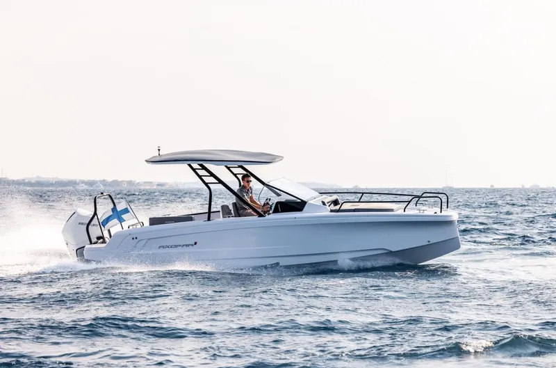 Slide: The Image of 2025 Axopar 25 Cross Top boat interior with seating and table, showcasing modern design. - 3