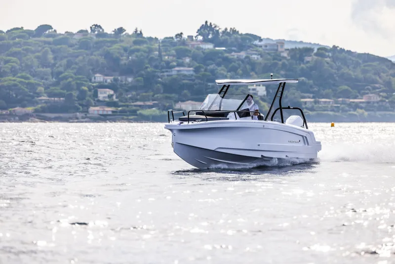 Slide: The Image of 2025 Axopar 25 Cross Top boat interior with seating and table at a boat show. - 4