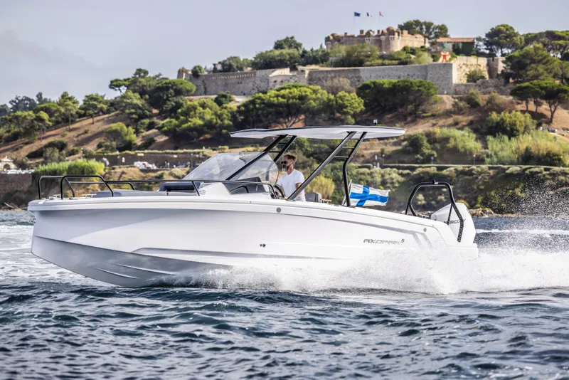 Slide: The Image of 2025 Axopar 25 Cross Top boat interior with cushioned seating and a central table. - 5