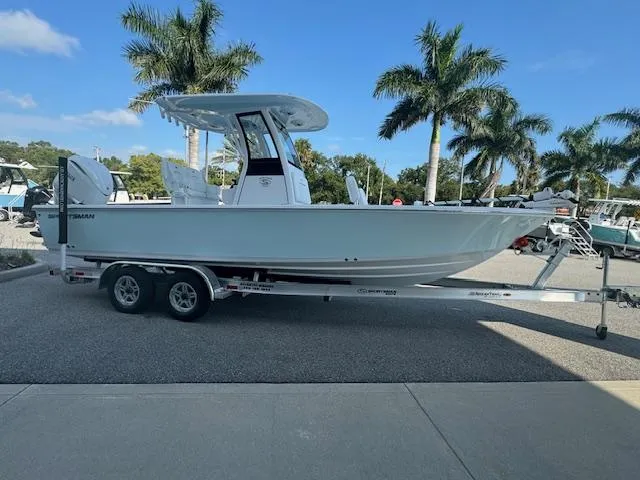 Slide: The Image of 2025 Sportsman Masters 247 Bay Boat on trailer, parked near palm trees. - 1
