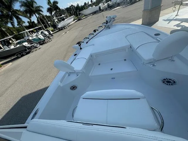 Slide: The Image of 2025 Sportsman Masters 247 Bay Boat, white interior, docked with palm trees in the background. - 3
