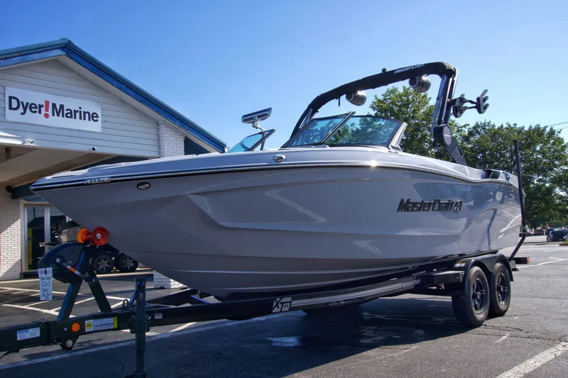 Slide: The Image of 2025 MasterCraft XT23 boat on trailer at Dyer Marine dealership. - 11