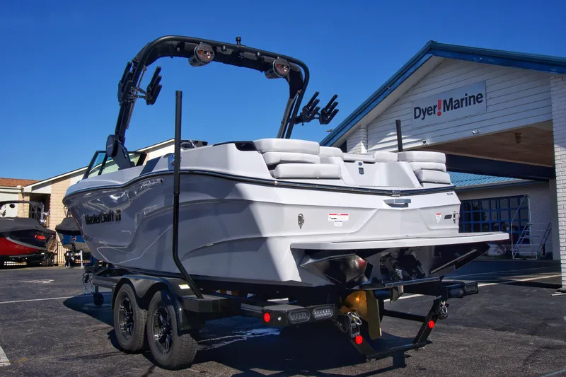 Slide: The Image of 2025 MasterCraft XT23 boat at Dyer Marine dealership, rear view. - 13