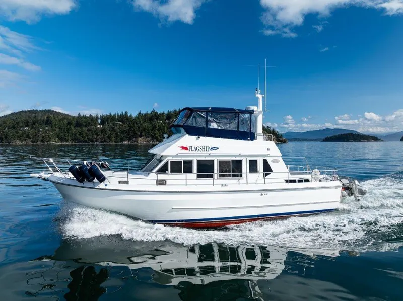 The Image of Symbol 42 Classic Trawler 2000 cruising on a serene lake under a clear blue sky. - 0