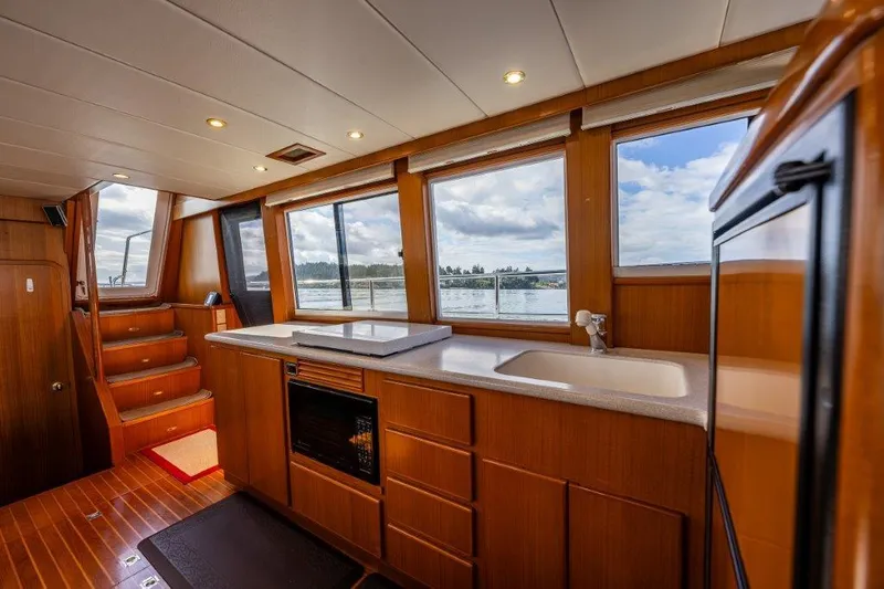 Slide: The Image of Interior of 2000 Symbol 42 Classic Trawler with wooden cabinetry and large windows. - 11