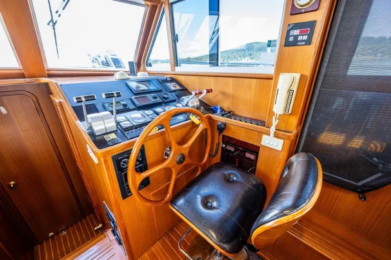 Slide: The Image of Symbol 42 Classic Trawler 2000 helm with wooden wheel and navigation controls. - 13