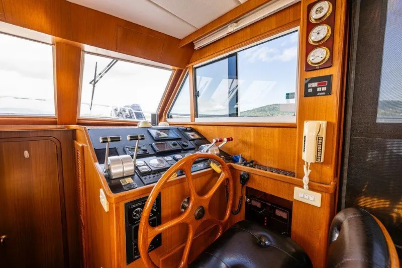 Slide: The Image of Interior helm of 2000 Symbol 42 Classic Trawler with wooden steering wheel and navigation instruments. - 14