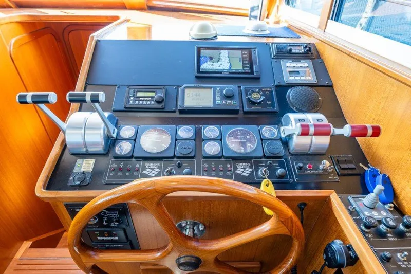 Slide: The Image of Control panel of a 2000 Symbol 42 Classic Trawler with wooden steering wheel and navigation instruments. - 16