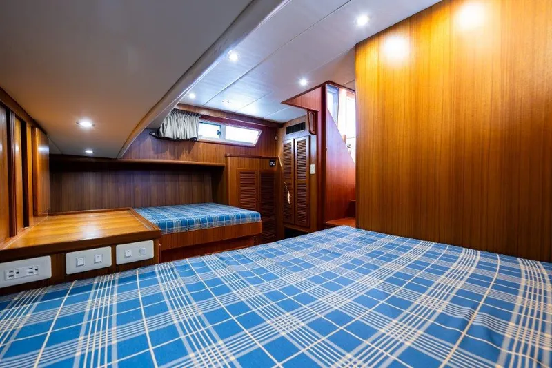 Slide: The Image of Interior of 2000 Symbol 42 Classic Trawler with wood paneling and blue plaid bedding. - 21