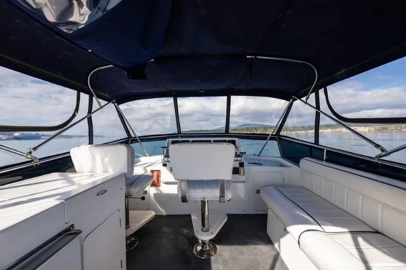 Slide: The Image of Interior view of 2000 Symbol 42 Classic Trawler with white seating and ocean backdrop. - 29