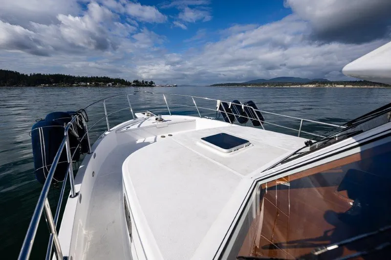 Slide: The Image of Symbol 42 Classic Trawler 2000 cruising on calm waters under a partly cloudy sky. - 3