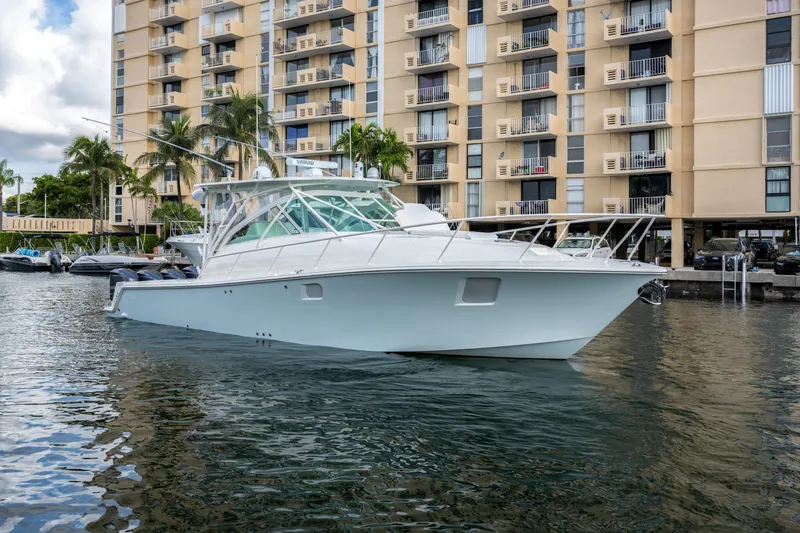 Slide: The Image of 2011 SeaVee 430 Sport Express boat docked near waterfront apartments. - 9