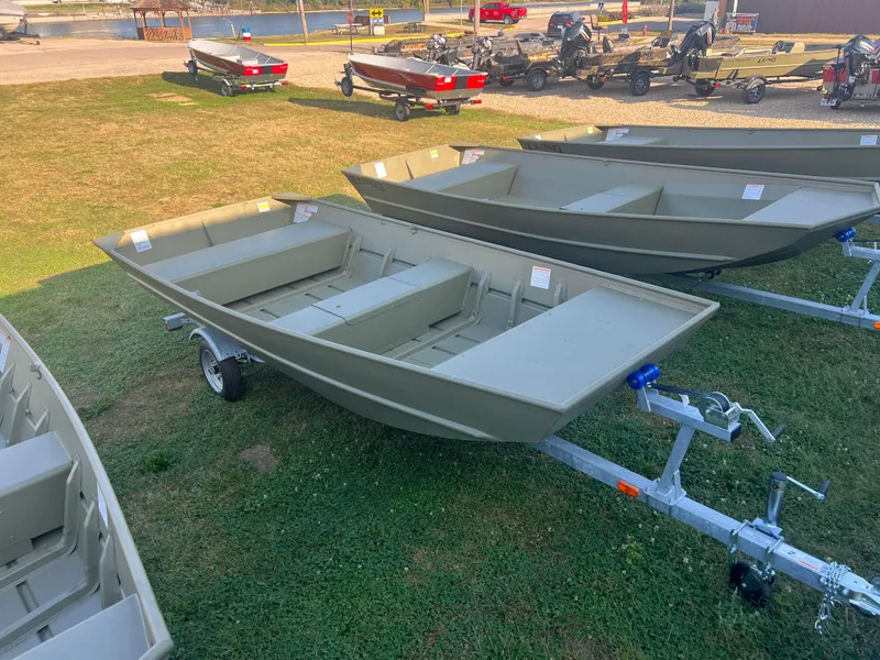 The Image of 2025 Lund 1448 boat on trailer, displayed on grass with other boats in background. - 0