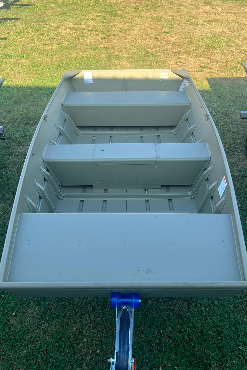 Slide: The Image of 2025 Lund 1448 boat on grass, showcasing interior seating and structure. - 1