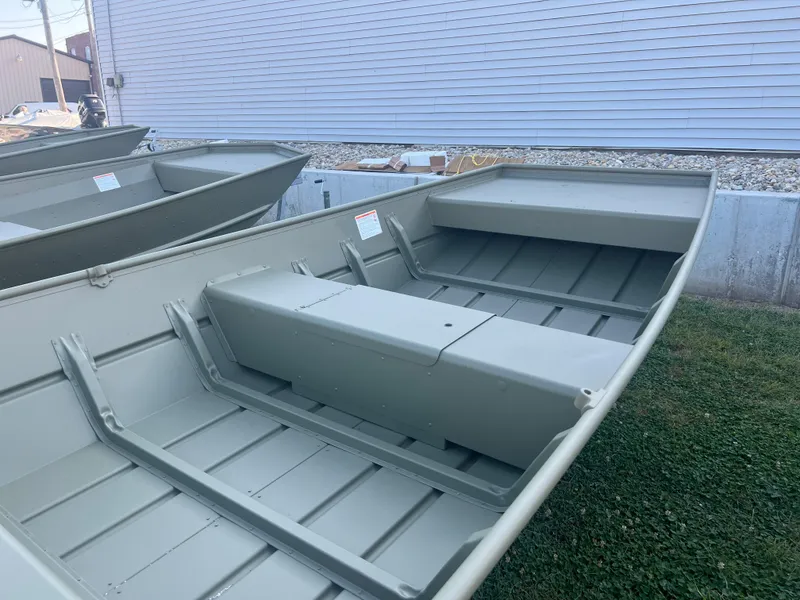 Slide: The Image of 2025 Lund 1448 boat, aluminum hull, parked on grass near building. - 4