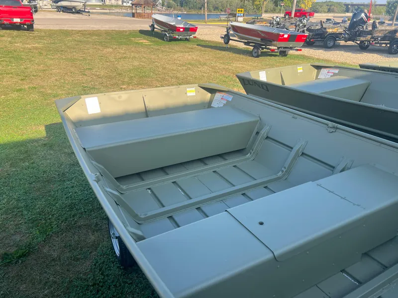 Slide: The Image of 2025 Lund 1448 boat on grass, showcasing interior seating and storage. - 5