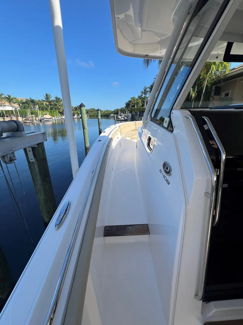 Slide: The Image of 2020 Pursuit S408 boat docked by a serene waterfront. - 18