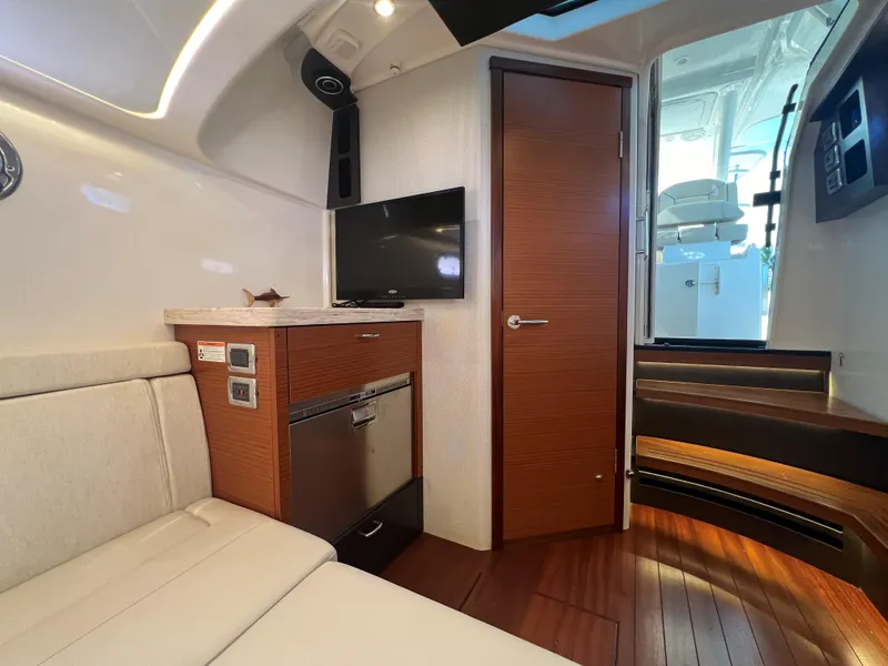 Slide: The Image of 2020 Pursuit S408 yacht interior with wood accents, TV, and seating area. - 22