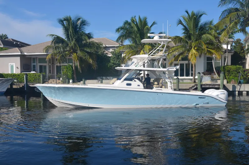 Slide: The Image of 2020 Pursuit S408 boat docked near waterfront homes with palm trees. - 3