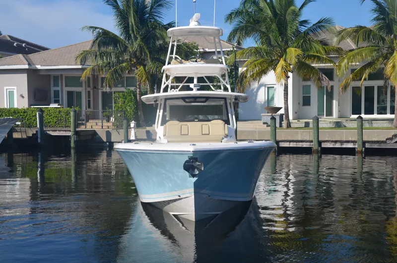 Slide: The Image of 2020 Pursuit S408 boat docked near waterfront homes with palm trees. - 4