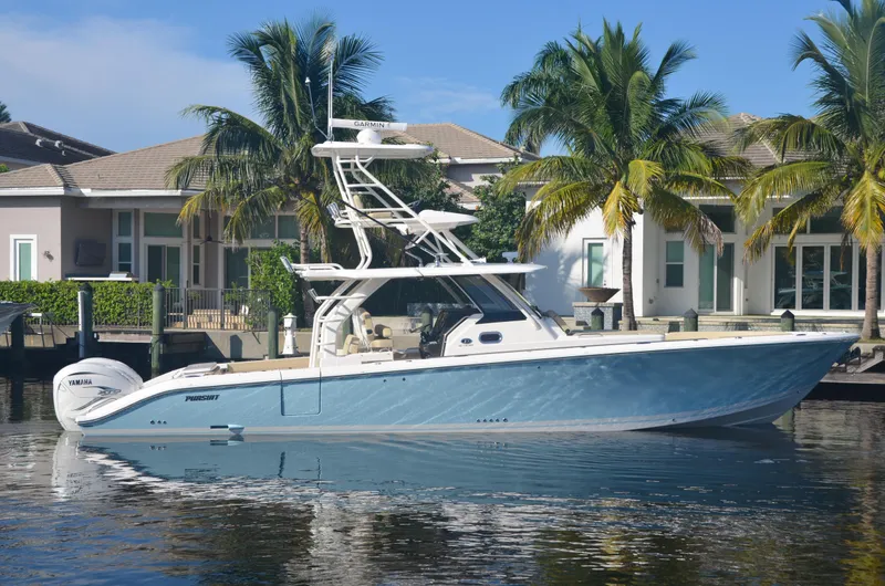 Slide: The Image of 2020 Pursuit S408 boat docked by waterfront homes with palm trees. - 5