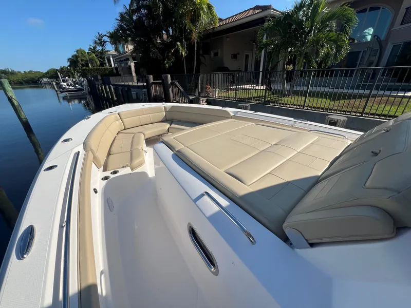 Slide: The Image of 2020 Pursuit S408 boat with beige seating, docked by a canal. - 8
