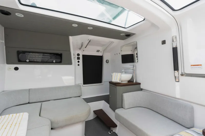 Slide: The Image of 2023 Axopar 37XC CROSS CABIN interior with modern seating and skylight. - 10