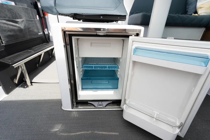 Slide: The Image of Open mini fridge inside 2023 Axopar 37XC CROSS CABIN boat interior. - 11