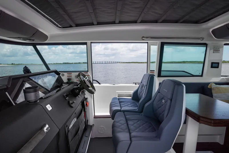 Slide: The Image of Interior of 2023 Axopar 37XC CROSS CABIN with blue seats and water view. - 5