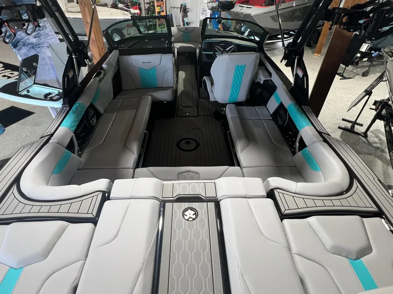 Slide: The Image of 2025 MasterCraft XT23 boat interior with gray and teal seating, spacious layout. - 4