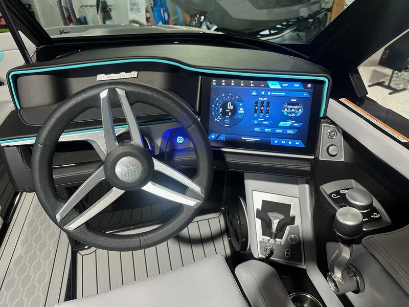Slide: The Image of 2025 MasterCraft XT23 boat dashboard with touchscreen controls and modern steering wheel. - 6