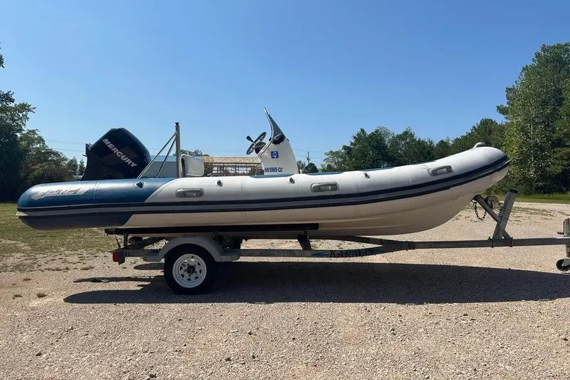 Slide: The Image of 2008 Valiant RIBs V520 boat on trailer, parked outdoors under clear blue sky. - 1