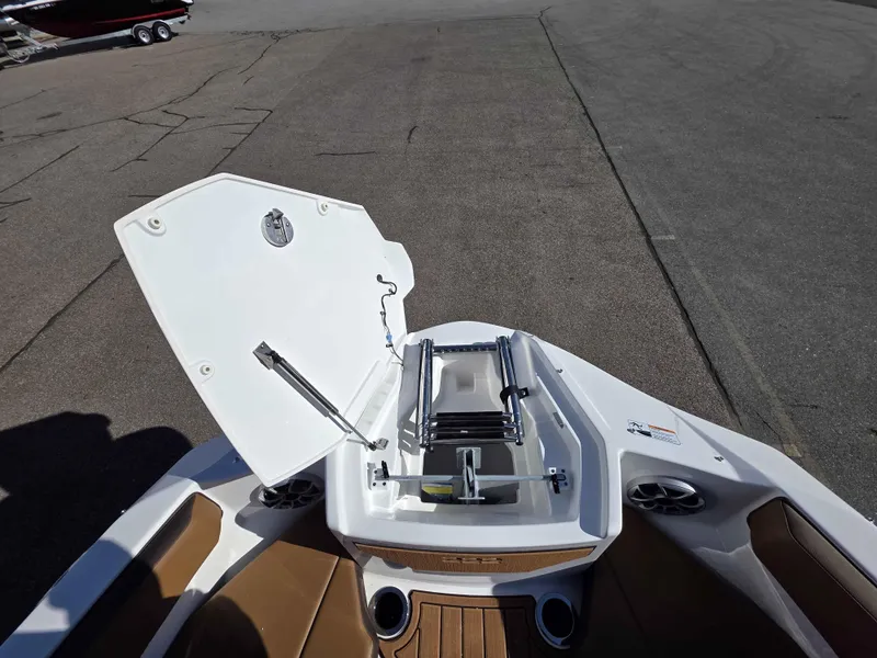 Slide: The Image of 2025 Yamaha Boats 222SE bow with open storage compartment and ladder. - 10