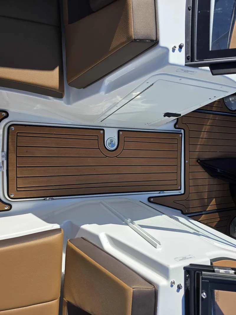 Slide: The Image of 2025 Yamaha Boats 222SE interior with brown seating and wood-style flooring. - 11
