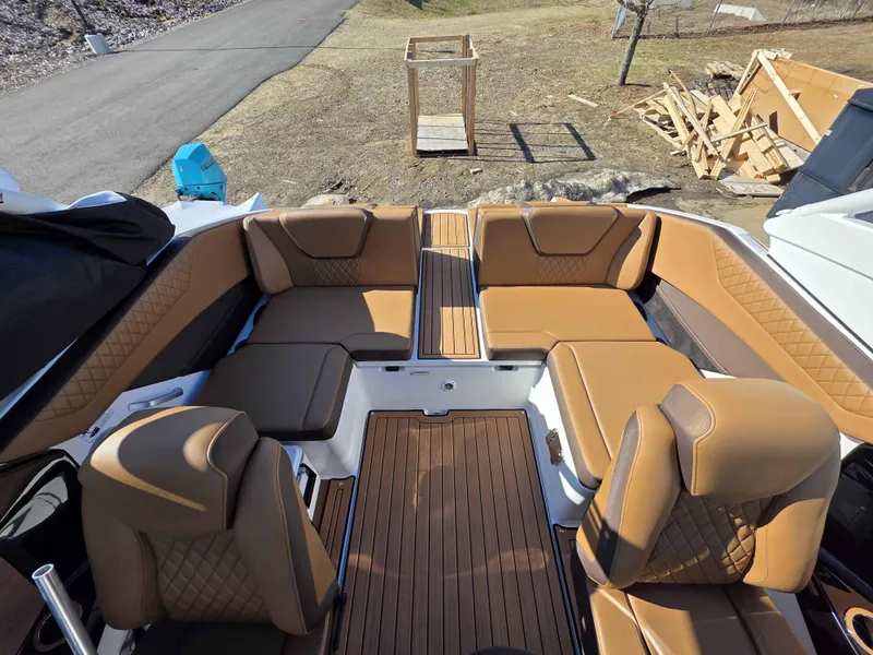 Slide: The Image of 2025 Yamaha Boats 222SE interior with tan leather seating and wood flooring. - 14
