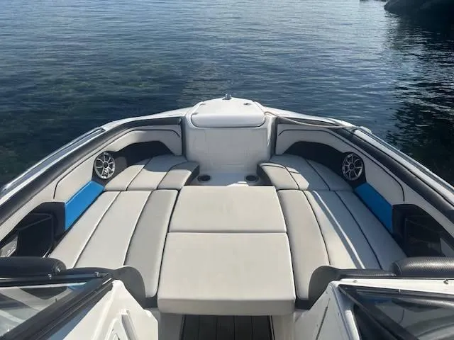 Slide: The Image of 2019 Yamaha Boats 212X interior with cushioned seating on calm water. - 10