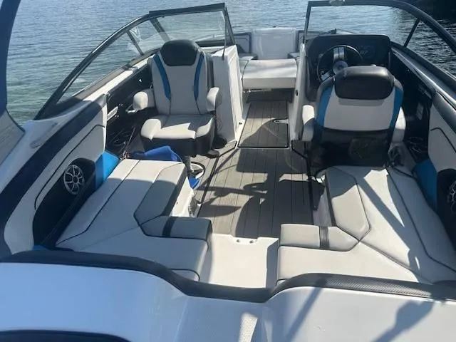 Slide: The Image of 2019 Yamaha Boats 212X interior with seating and steering wheel on calm water. - 5