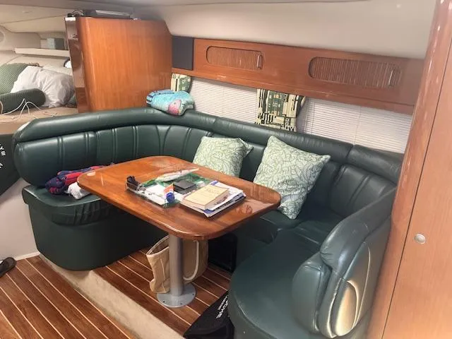 Slide: The Image of Interior of 2000 Four Winns 328 Vista boat with green leather seating and wooden table. - 14