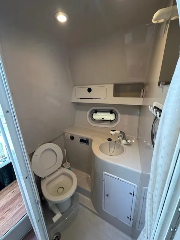 Slide: The Image of Compact bathroom in 2000 Four Winns 328 Vista boat with toilet, sink, and shower. - 18