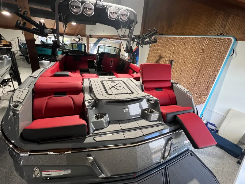 Slide: The Image of 2025 MasterCraft X24 boat with red seating and sleek design in showroom. - 4