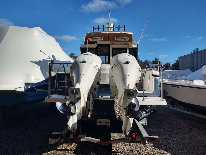 Slide: The Image of 2018 Cutwater C-302 Coupe with dual outboard motors, parked on a trailer. - 2