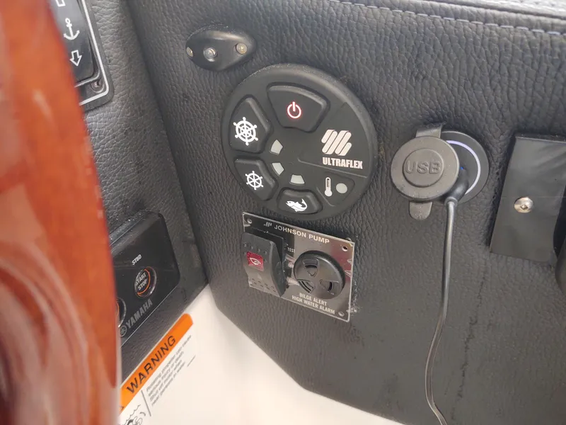 Slide: The Image of Control panel of a 2018 Cutwater C-302 Coupe boat with USB port and warning label. - 32