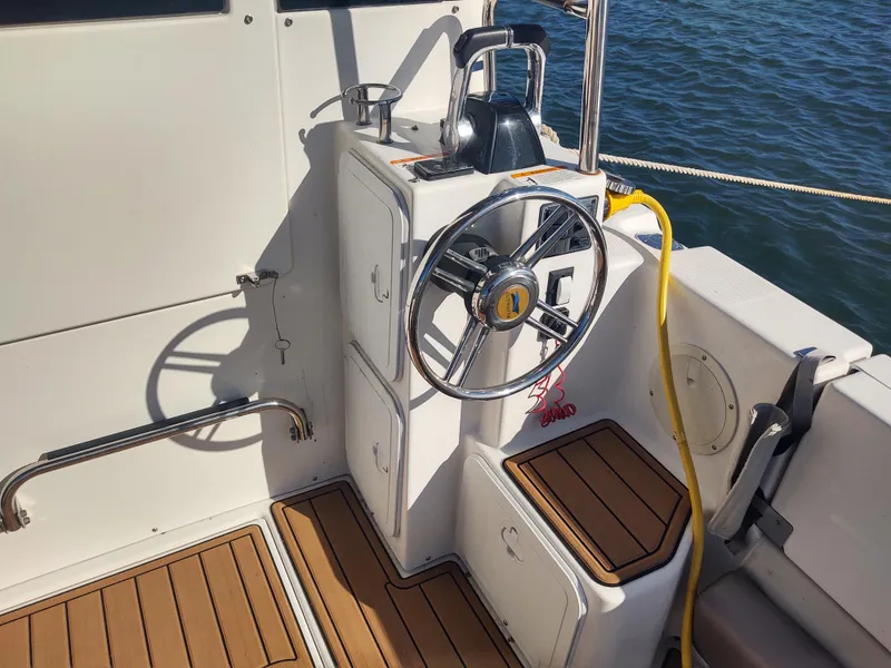 Slide: The Image of 2018 Cutwater C-302 Coupe helm with steering wheel and teak flooring, docked by water. - 46