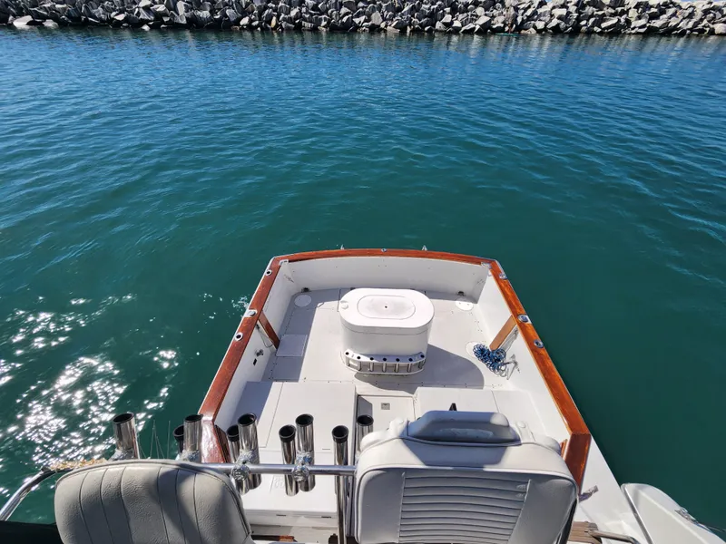 Slide: The Image of 1988 Chris-Craft 315 Commander boat on calm water, featuring a spacious deck. - 17