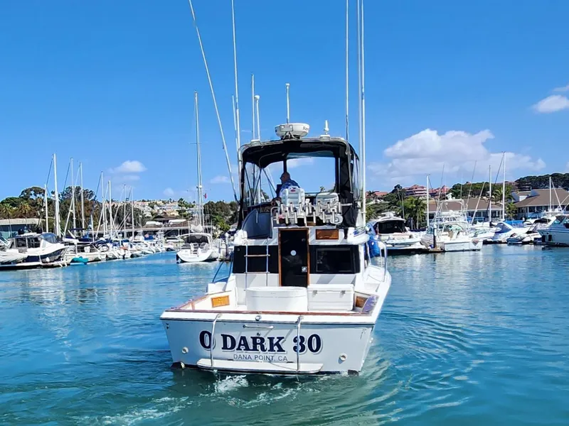 Slide: The Image of 1988 Chris-Craft 315 Commander boat in marina, clear blue sky, calm water. - 2
