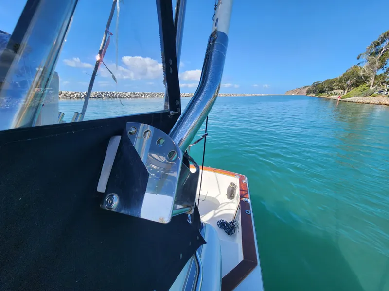 Slide: The Image of 1988 Chris-Craft 315 Commander on serene blue water, clear sky, coastal view. - 21