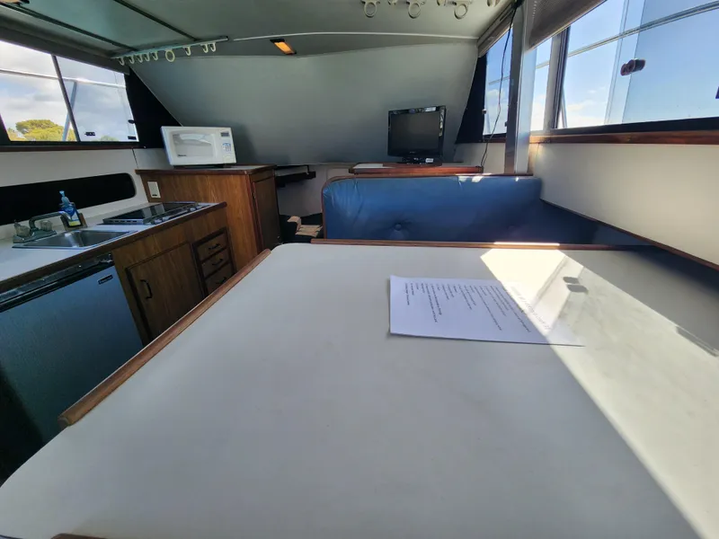 Slide: The Image of Interior of 1988 Chris-Craft 315 Commander boat with kitchenette and seating area. - 25